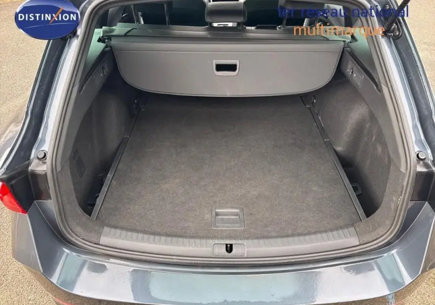 Coffre ouvert d'une CUPRA Leon ST gris 3/4 arrière, montrant un espace de chargement spacieux et propre.