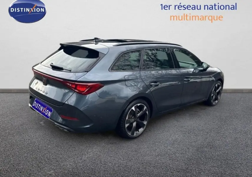 Vue 3/4 arrière droite d'une CUPRA Leon ST gris avec toit ouvrant panoramique et jantes aluminium.