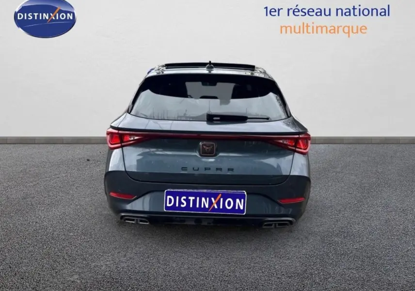 Vue arrière d'une CUPRA Leon ST gris 2024 avec feux reliés et double sortie d'échappement intégrée.