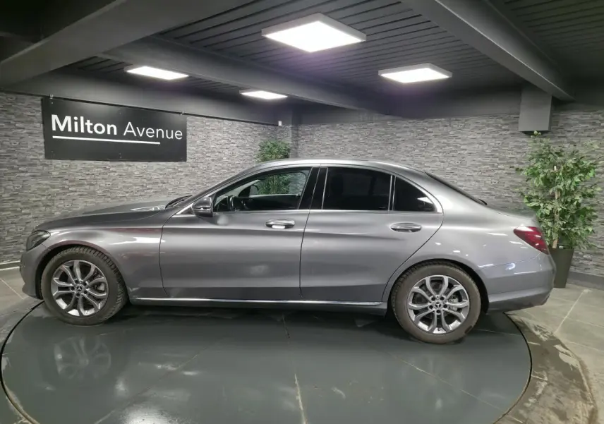 Vue latérale droite d'une Mercedes Classe C gris métallisé avec jantes alliage 17 pouces et vitres arrière teintées.