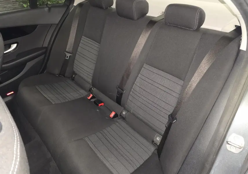 Vue intérieure de la banquette arrière en tissu gris foncé de la Mercedes Classe C 2018, avec ceintures de sécurité visibles.