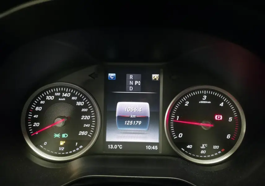 Vue rapprochée du combiné d'instruments noir de la Mercedes Classe C 2018, affichant vitesse, compte-tours et écran central.