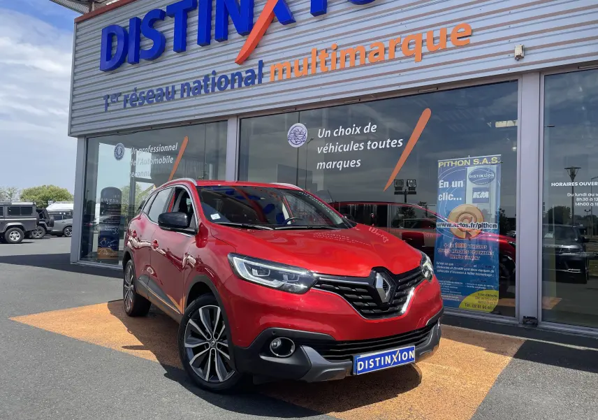 Renault Kadjar rouge flamme en 3/4 avant droit, stationné devant un concessionnaire multimarque Distinxion.