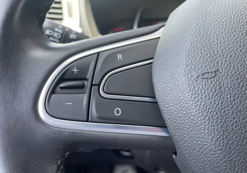 Gros plan sur les commandes au volant noir du Renault Kadjar 1.6 DCi 130 CVT Energy Intense 2018, finition cuir.