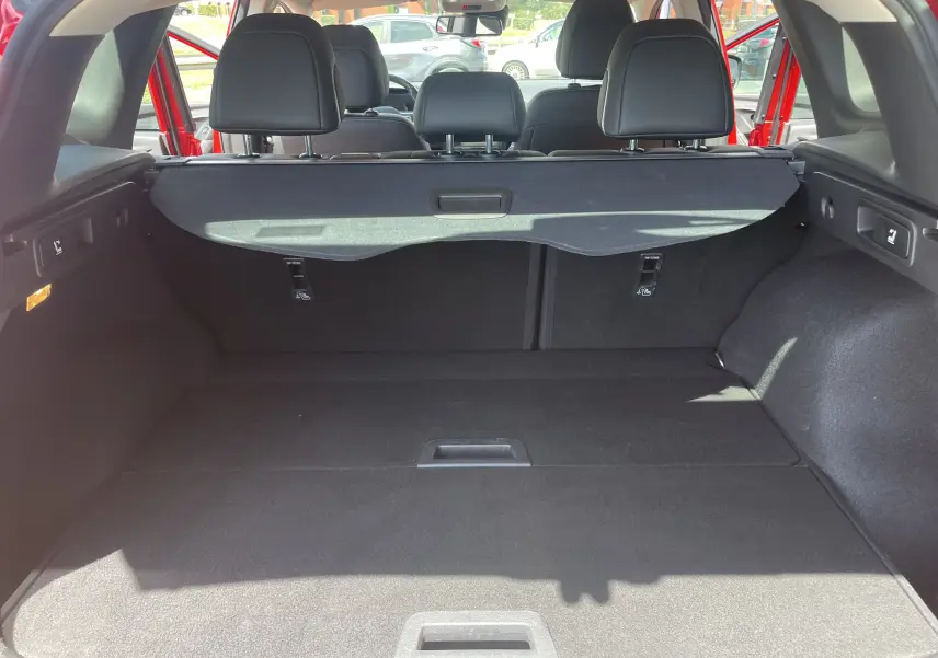 Vue arrière du coffre spacieux du Renault Kadjar rouge flamme 2018, avec cache-bagages et sièges arrière rabattables.
