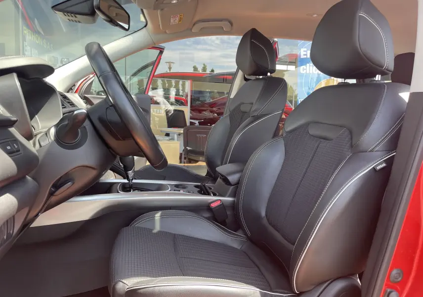 Vue intérieure côté conducteur du Renault Kadjar rouge flamme 2018, sièges en cuir noir avec surpiqûres blanches.