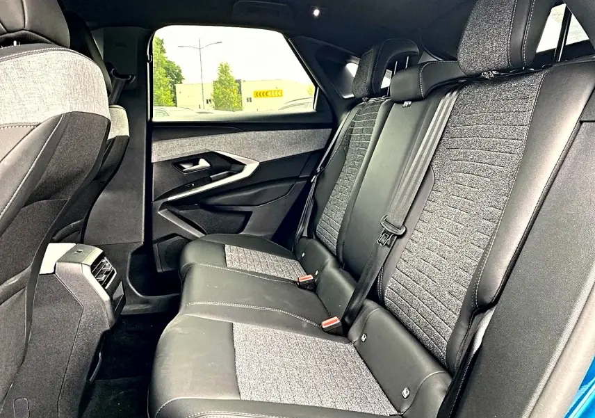 Vue intérieure côté droit des sièges arrière gris et noir du Peugeot 3008 1.2 hybrid 145 allure e-dcs6 bleu 2025.