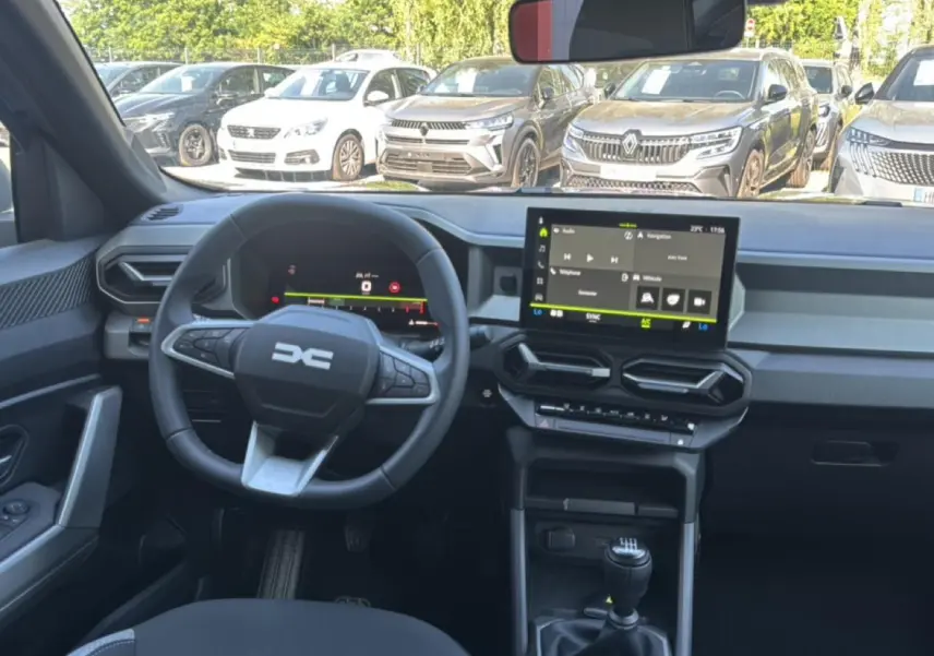 Intérieur du Dacia Bigster gris schiste, vue frontale du poste de conduite avec volant multifonction et écran tactile central.