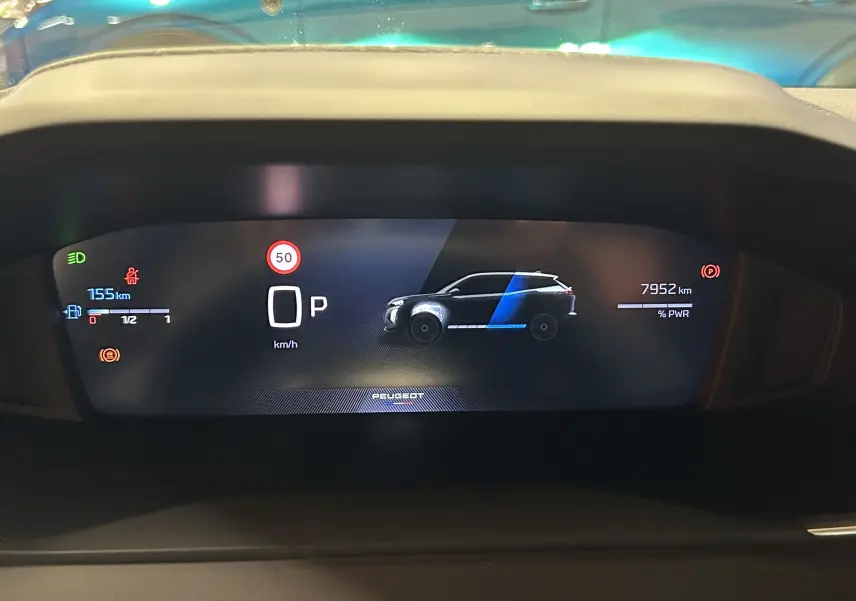 Tableau de bord numérique du Peugeot 2008 hybride, affichant la vitesse, l'autonomie et l'icône du véhicule en profil.