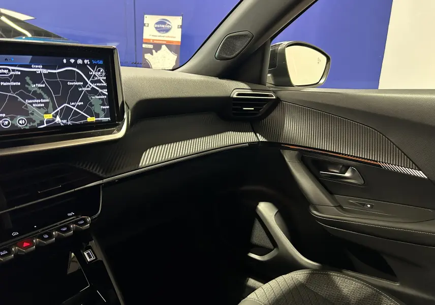 Intérieur de la Peugeot 2008 II Hybrid 110, vue côté passager avec écran GPS et finitions noires texturées.