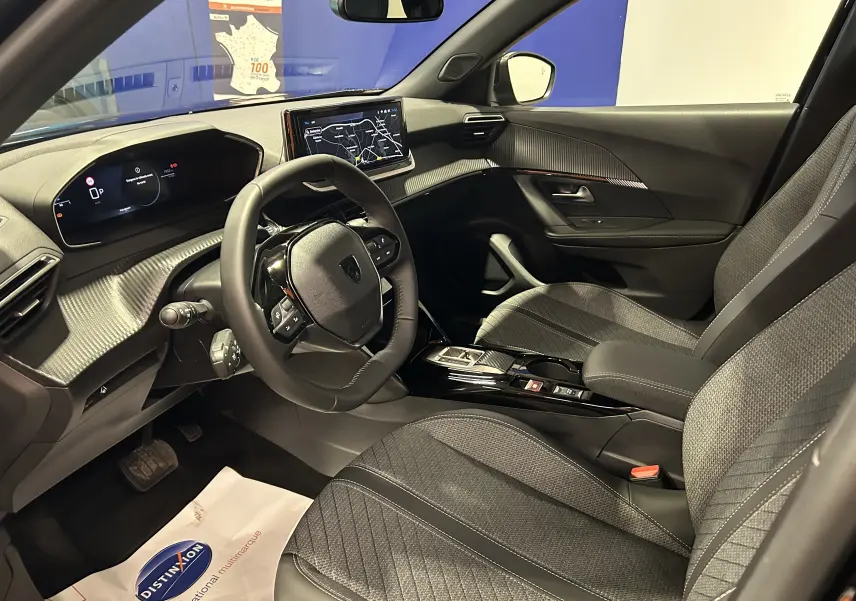 Intérieur avant droit de la Peugeot 2008 II Hybrid noir, avec tableau de bord numérique et écran tactile GPS.