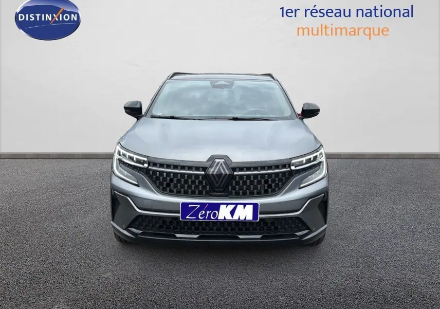 Vue frontale du Renault Austral 2024 gris schiste satin mat avec calandre noire et feux LED distinctifs allumés.