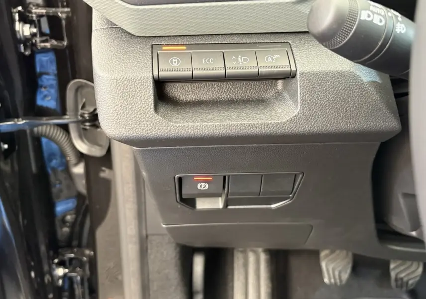 Détail du tableau de bord noir du Dacia Duster 2025 avec commandes ECO et frein de stationnement électrique.