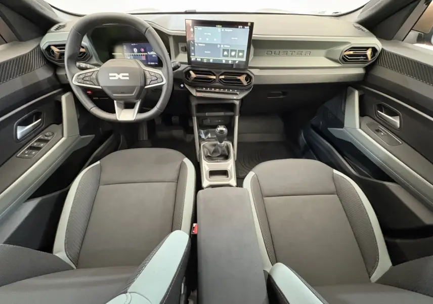 Vue intérieure avant du Dacia Duster 2025 noir, volant multifonctions, écran tactile central et boîte manuelle.