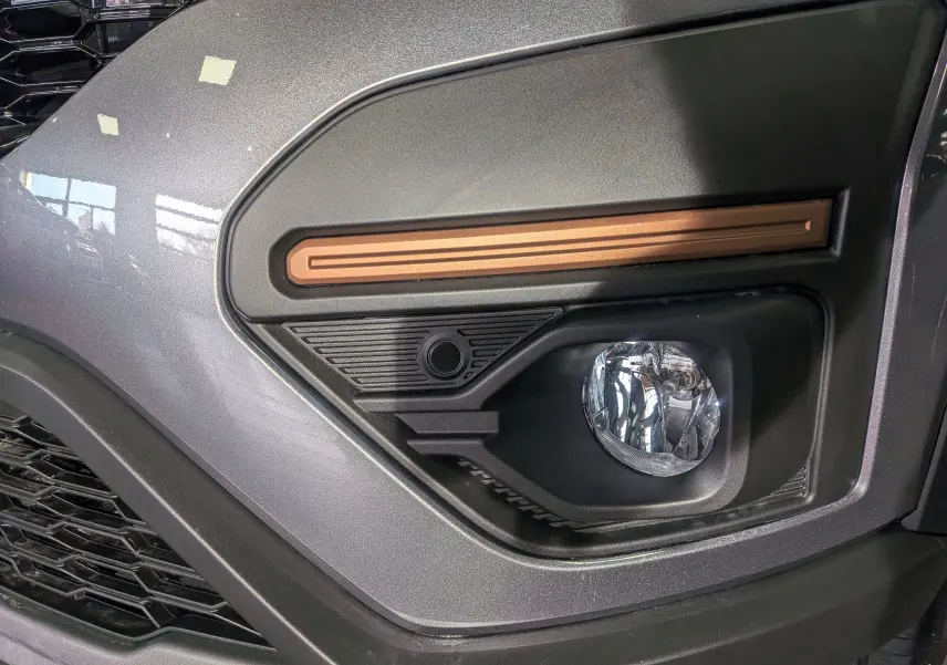 Gros plan sur le feu antibrouillard droit de la Dacia Sandero Stepway gris schiste avec insert décoratif cuivre.