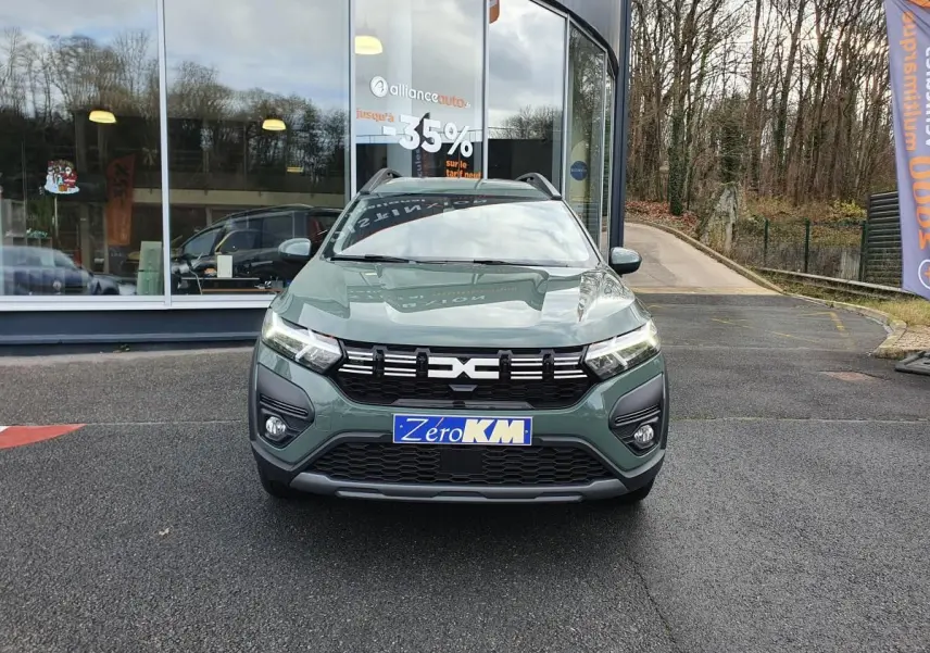 Vue frontale d'un Dacia Jogger 2024 hybride en vert lichen avec barres de toit et calandre noire.
