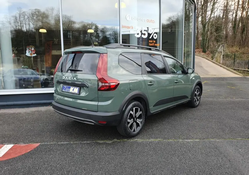 Vue 3/4 arrière droite du Dacia Jogger 2024 hybride en Licken Kaki avec barres de toit et feux arrière LED distinctifs.