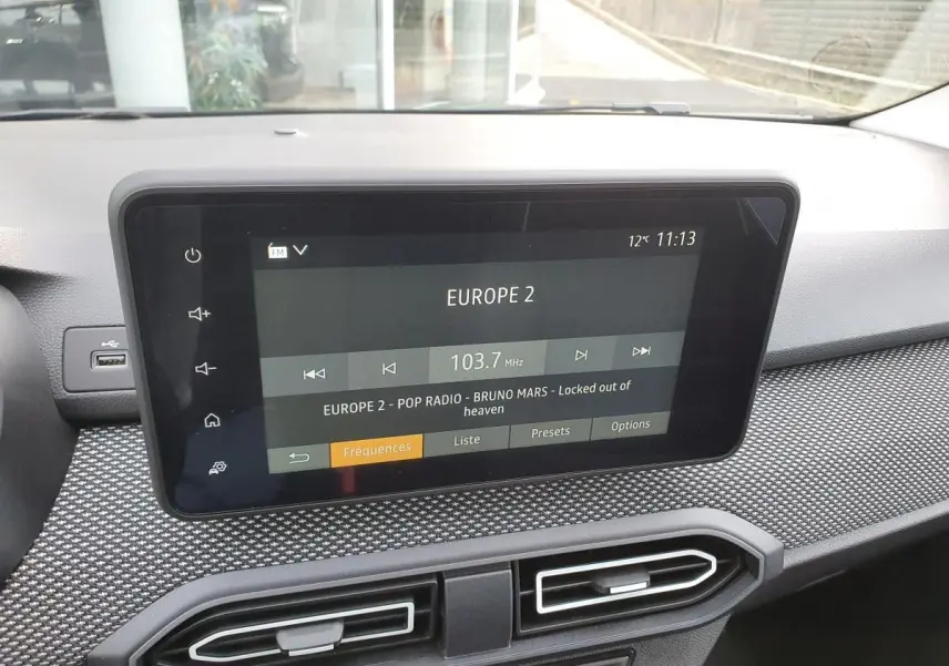 Écran tactile central du tableau de bord du Dacia Jogger 2024 affichant la radio Europe 2, avec finition texturée grise.