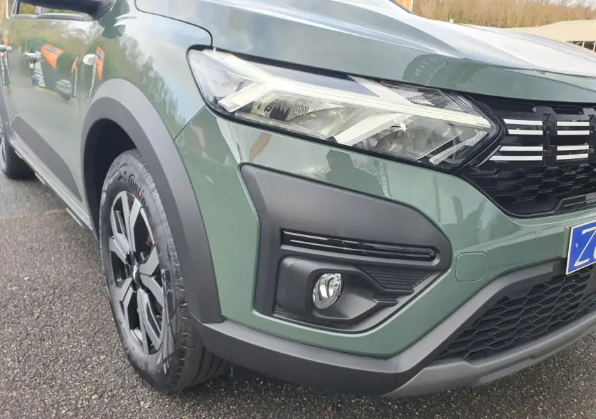 Vue 3/4 avant gauche d'un Dacia Jogger 2024 en vert Licken Kaki avec phares LED et jantes noires bicolores.