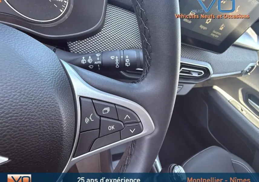 Vue rapprochée de l’intérieur du Dacia Jogger gris 2025, volant multifonction et tableau de bord avec écran tactile.