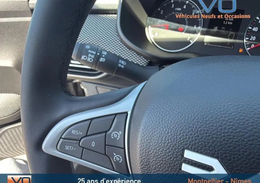 Gros plan sur le volant noir du Dacia Jogger 2025 avec commandes de régulateur de vitesse et tableau de bord partiel.