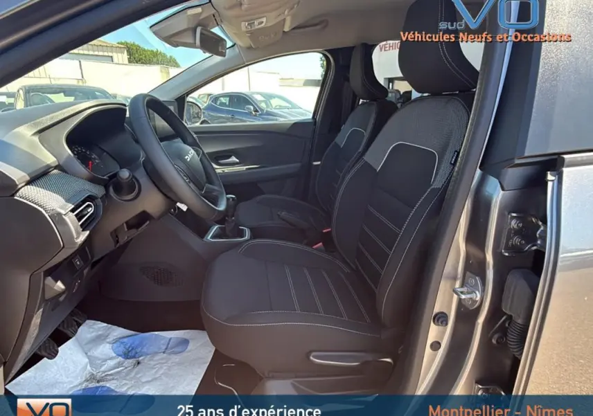 Vue intérieure côté conducteur du Dacia Jogger gris 2025, montrant les sièges avant et le volant réglable.