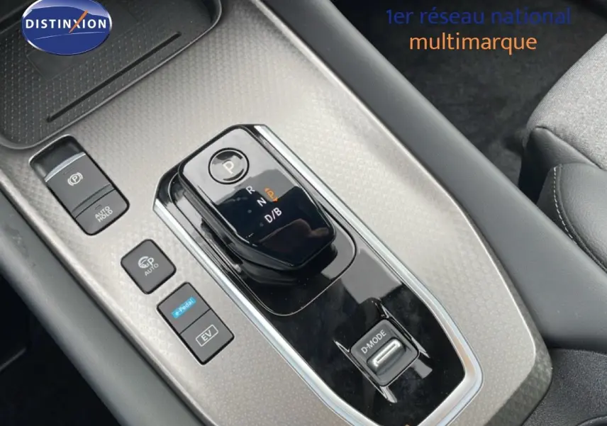 Gros plan sur la console centrale du Nissan Qashqai gris Squale Metal, montrant la commande de boîte automatique et les boutons de mode de conduite.