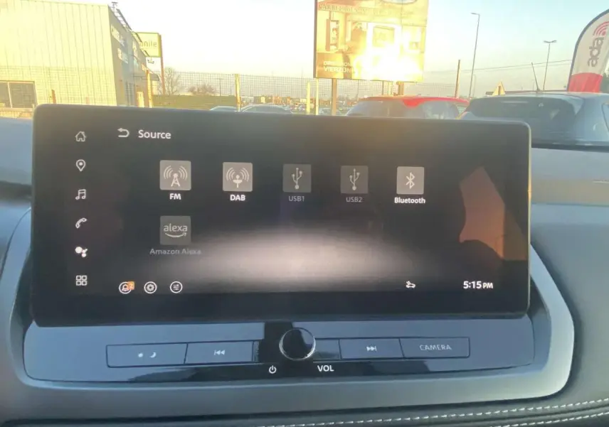 Vue intérieure du tableau de bord du Nissan Qashqai 2025, écran tactile affichant les options audio avec commandes sous l'écran.