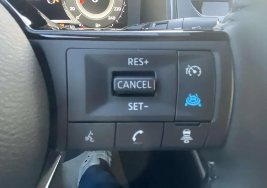 Gros plan sur les commandes au volant côté droit du Nissan Qashqai gris ceramic 2025 avec régulateur de vitesse et aides à la conduite.