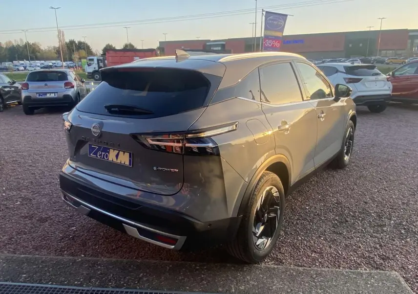 Vue 3/4 arrière droite du Nissan Qashqai 2025 gris ceramic avec détails noirs et feux arrière LED distinctifs.