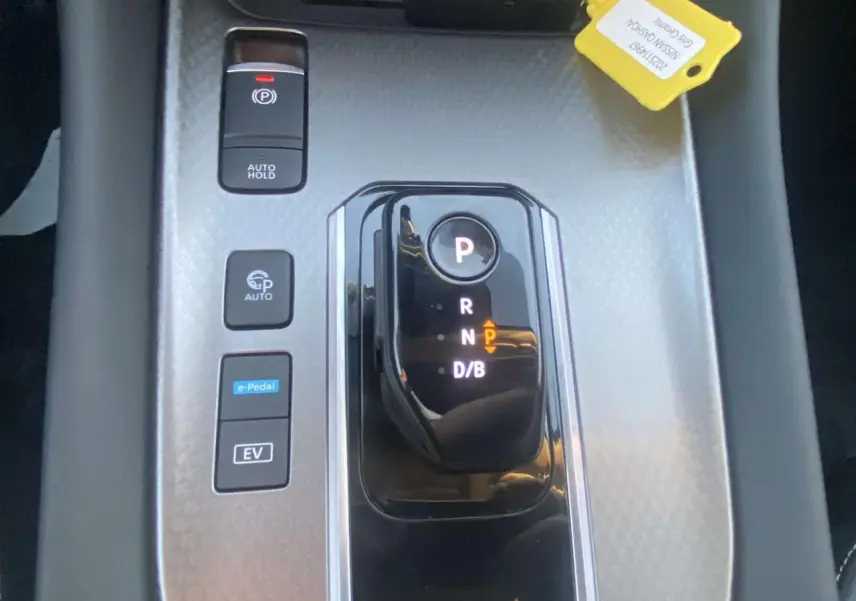 Gros plan sur la console centrale grise du Nissan Qashqai 2025 avec levier de vitesses automatique et boutons e-Pedal et EV.
