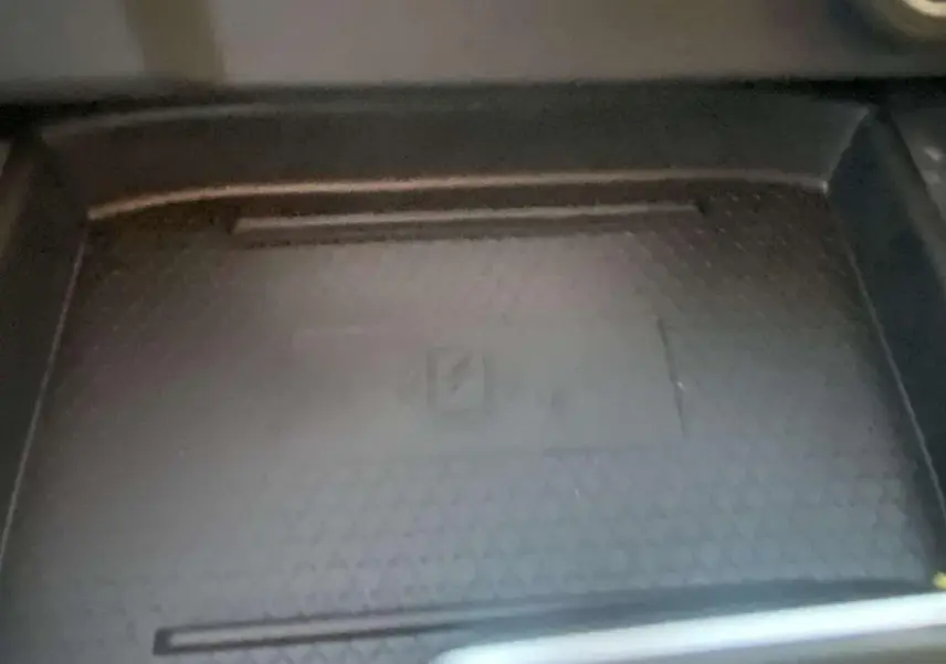 Détail du compartiment de rangement intérieur du Nissan Qashqai 2025 en gris ceramic, avec surface texturée.