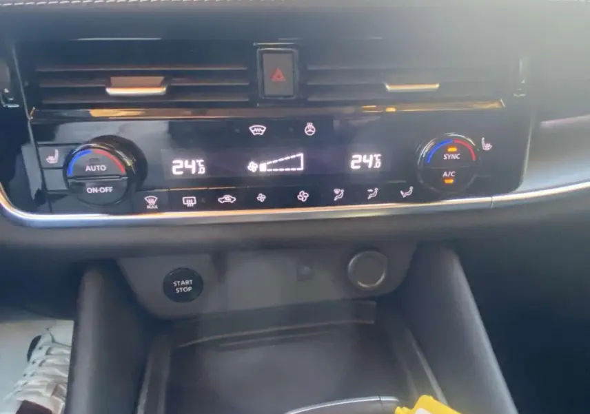 Vue rapprochée du tableau de bord du Nissan Qashqai 2025, montrant la climatisation digitale à 24°C et le bouton Start/Stop.