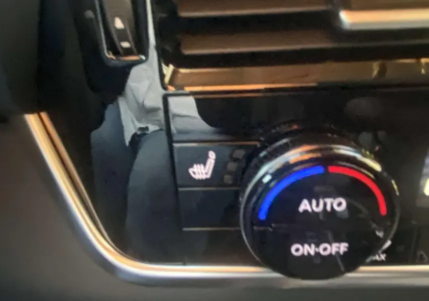 Gros plan sur la molette de réglage de la climatisation automatique avec fonction siège chauffant du Nissan Qashqai gris ceramic.