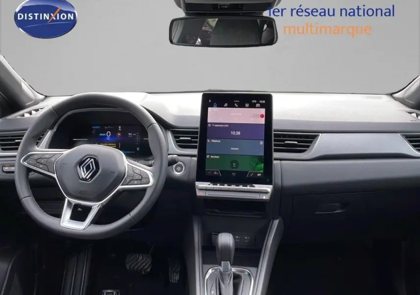 Vue intérieure frontale du tableau de bord et volant cuir du Renault Captur gris 2025 avec écran tactile vertical.