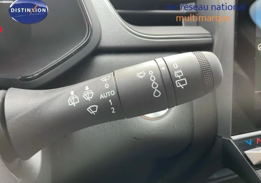 Gros plan sur la commande des essuie-glaces du Renault Captur gris 2025, avec détails des symboles et tableau de bord partiel.