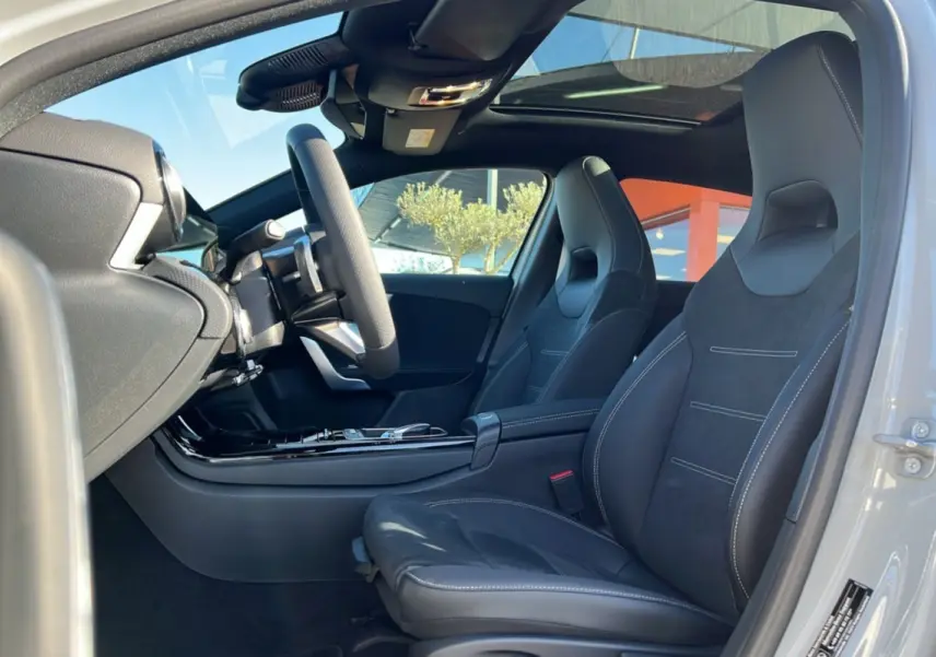 Vue intérieure côté conducteur de la Mercedes Classe A 200D BVA Exclusive Design avec sièges sport cuir tissu et toit panoramique.