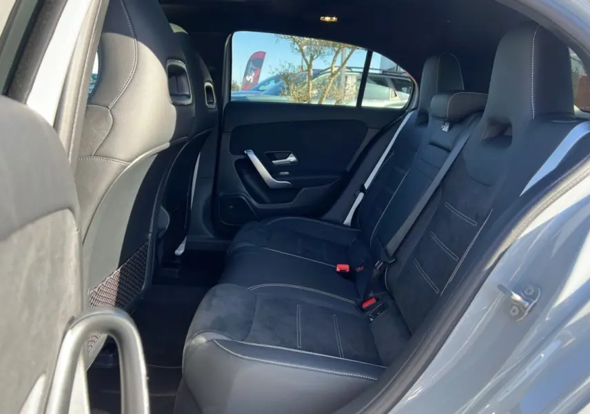 Vue intérieure arrière droite de la Mercedes Classe A 200D Exclusive Design avec sellerie cuir tissu noire et ciel de pavillon noir.