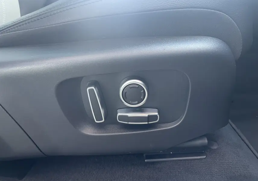 Détail des commandes de réglage électrique du siège côté gauche dans un Range Rover Evoque Portofino Blue 2022.