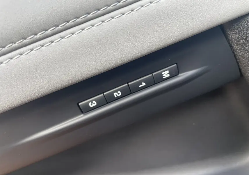 Détail des boutons de mémorisation des réglages de siège sur la porte intérieure grise d'un Range Rover Evoque 2022.