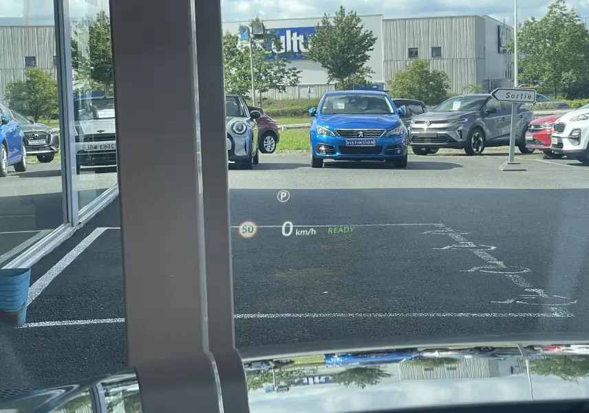 Vue depuis l'intérieur du Range Rover Evoque bleu Portofino, affichage tête haute visible sur le pare-brise.
