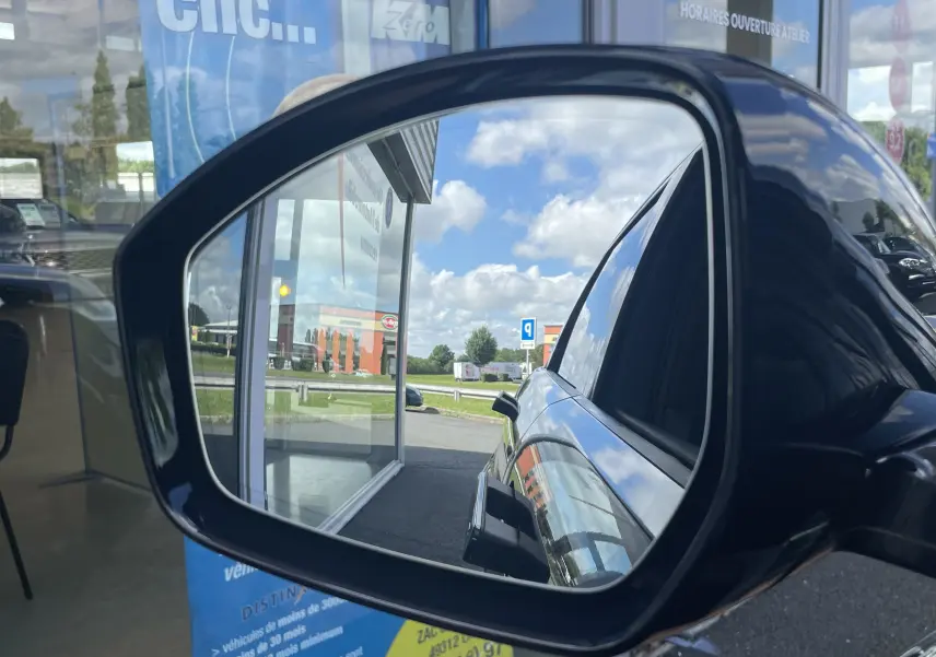 Reflet dans le rétroviseur gauche d'un Range Rover Evoque 2022 bleu Portofino, montrant la portière et la vitre teintée.