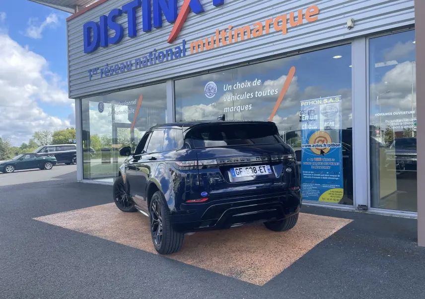 Vue 3/4 arrière d'un Range Rover Evoque 2022 hybride rechargeable en bleu Portofino, avec jantes noires et toit noir brillant.