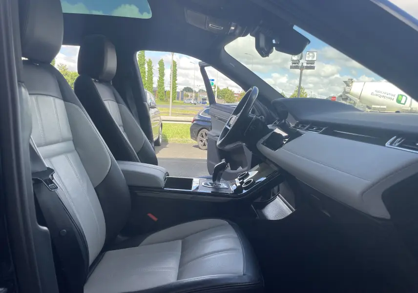 Vue intérieure côté conducteur du Range Rover Evoque 2022, sièges cuir gris noir et tableau de bord moderne.