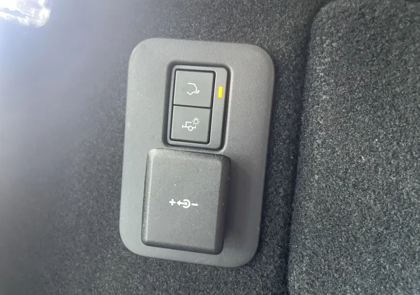 Gros plan sur les boutons de réglage électrique du hayon et de l’éclairage dans le coffre du Range Rover Evoque 2022.