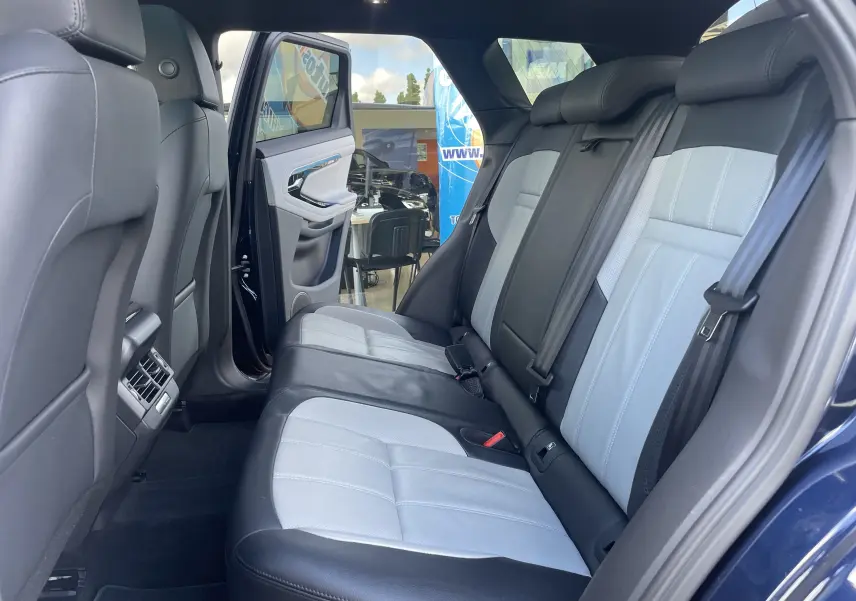 Vue intérieure côté droit sur la banquette arrière cuir bicolore gris clair et noir du Range Rover Evoque Portofino Blue 2022.