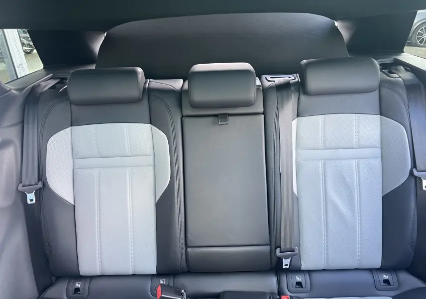 Vue intérieure arrière montrant les sièges en cuir bi-ton gris clair et noir du Range Rover Evoque 2022.