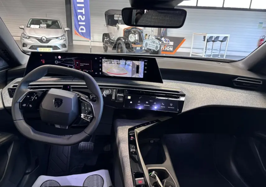 Vue intérieure du poste de conduite du Peugeot 3008 blanc, avec tableau de bord numérique panoramique et volant compact cuir.