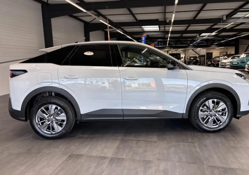 Vue latérale droite d’un Peugeot 3008 blanc hybride 2026 avec jantes alliage 18 pouces et vitres arrière teintées.