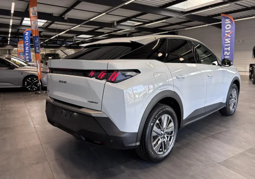Vue 3/4 arrière droite du Peugeot 3008 blanc hybride avec feux arrière LED à 3 griffes et jantes alliage 18 pouces.